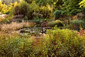 KNOLL GARDENS, DORSET: SEPTEMBER, GRASSES, THE DRAGON GARDEN, POND, POOL, WATER, SCULPTURE, FOUNTAIN
