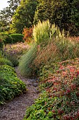 KNOLL GARDENS, DORSET: SEPTEMBER, PATH, FUCHSIA MAGELLANICA VAR. GRACILIS VERSICOLOR, PAMPAS GRASS, CORTADERIA SUNNINGDALE SILVER, ORNAMENTAL GRASSES