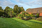 PRIVATE GARDEN, BERKSHIRE: ISTVAN DUDAS; PHALARIS ARUNDINACEA PICTA, DAHLIA FASCINATION, HELIANTHUS ANNUUS ASTRA ROSE, LAWN, BARN