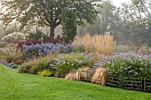 JOHN MASSEY GARDEN, ASHWOOD NURSERIES, WORCESTERSHIRE: SEPTEMBER, CALAMAGROSTIS KARL FOERSTER, PENNISETUM DARK DESIRE, SYMPHYOTRICHUM LITTLE CARLOW, BERBERIS ORANGE ROCKET
