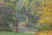 JOHN MASSEY GARDEN, ASHWOOD NURSERIES, WORCESTERSHIRE: SEPTEMBER, VIEW TO CANAL AND TERRACOTTA CONTAINER