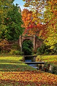 LLANOVER GARDEN, MONMOUTHSHIRE: AUTUMN COLOUR, FALL, OCTOBER, STREAM, BRIDGES, WALL, NYSSA SYLVATICA