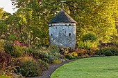 LLANOVER GARDEN, MONMOUTHSHIRE: WALLED, ROUND GARDEN, OCTOBER, BORDER, LAWN, PATH, DOVECOTE, GRASSES, PERENNIALS, SALVIAS, DAHLIA DAVID HOWARD, VITIS COIGNETIAE