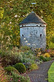 LLANOVER GARDEN, MONMOUTHSHIRE: WALLED, ROUND GARDEN, OCTOBER, BORDER, LAWN, PATH, DOVECOTE, GRASSES, PERENNIALS, SALVIAS, DAHLIA DAVID HOWARD, ASTERS, BERGENIA, BOX BALL