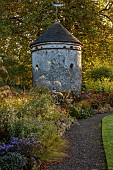 LLANOVER GARDEN, MONMOUTHSHIRE: WALLED, ROUND GARDEN, OCTOBER, BORDER, LAWN, PATH, DOVECOTE, GRASSES, PERENNIALS, SALVIAS, DAHLIA DAVID HOWARD, ASTERS, BERGENIA, BOX BALL