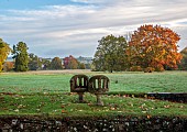 LLANOVER GARDEN, MONMOUTHSHIRE: OCTOBER, FALL, AUTUMN, STONE LOVE SEAT LOOKING OVER PARKLAND, LANDSCAPE