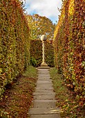 YORK GATE GARDEN, YORKSHIRE: AUTUMN, FALL, PATH, BARLEYSUGAR COLUMN, SUNDIAL, BEECH HEDGES, HEDGING, FOCAL POINT