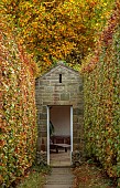 YORK GATE GARDEN, YORKSHIRE: AUTUMN, FALL, DOORWAY, PATH, BEECH HEDGES, HEDGING, FOCAL POINT, GARDEN ROOM, BUILDING, SUMMERHOUSE