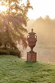 JOHN MASSEY GARDEN, ASHWOOD NURSERIES, WORCESTERSHIRE, FALL, AUTUMN, OCTOBER, TERRACOTTA URN, CONTAINER NEAR THE CANAL, LAWN, MIST, FOG, SUNRISE