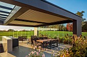 NATURAL SWIMMING POND GARDEN, ITALY BY GPT STUDIO, FALL, AUTUMN, OCTOBER, OUTDOOR, OUTSIDE, INSIDE LIVING ROOM OPEN ON ONE SIDE, TABLE, CHAIRS