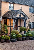 WOLLERTON OLD HALL, SHROPSHIRE: NOVEMBER, FROST, WINTER. FRONT ENTRANCE TO THE HALL, CLIPPED TOPIARY  SHAPES IN CONTAINERS