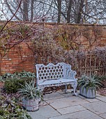 WOLLERTON OLD HALL, SHROPSHIRE: NOVEMBER, FROST, WINTER, THE WELL GARDEN, METAL BENCH, SEAT, CONTAINERS WITH ASTELIA, WALLS