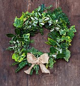 WOLLERTON OLD HALL, SHROPSHIRE: WREATH ON FRONT DOOR, CORYLUS AVELANA, TAXUS BACCATA, HEDERA, ILEX AQUIFOLIUM, PITTOSPORUM TENUIFOLIUM IRENE PATTERSON