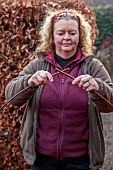 WOLLERTON OLD HALL, SHROPSHIRE: WREATH MAKING BY HEAD GARDENER CLAIRE TATLER, CORNUS SIBERICA STEMS HELD TOGETHER
