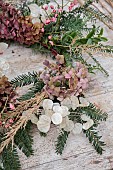 WOLLERTON OLD HALL, SHROPSHIRE: WREATH MAKING, CORNUS SIBERICA, LUNARIA ANNUA, YEW, HYDRANGEA WESTFALEN, CALAMAGROSTIS BRACHYTRICHA, EUONYMUS HAMILTONIANUS