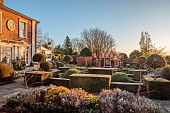 THE LASKETT GARDEN, HEREFORDSHIRE: WINTER, FROST, JANUARY, HOWDAH COURT, FORMAL GARDEN IN FRONT OF THE HOUSE, CLIPPED TOPIARY, KNOT GARDEN