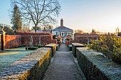 THE LASKETT GARDEN, HEREFORDSHIRE: WINTER, FROST, JANUARY, VIEW TO THE HOUSE AND FOUNTAIN COURT FROM THE COLONNADE COURT, YEW HEDGES, HEDGING, BEECH