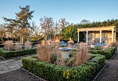 THE LASKETT GARDEN, HEREFORDSHIRE: WINTER, FROST, JANUARY, THE COLONNADE COURT, PARTERRE BEDS WITH URNS, GRASSES