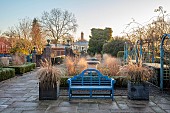 THE LASKETT GARDEN, HEREFORDSHIRE: WINTER, FROST, JANUARY, THE COLONNADE COURT, PARTERRE BEDS WITH URNS, GRASSES, BLUE BENCH, SEAT