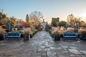 THE LASKETT GARDEN, HEREFORDSHIRE: WINTER, FROST, JANUARY, THE COLONNADE COURT, PARTERRE BEDS WITH URNS, GRASSES, BLUE BENCH, SEAT