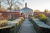 THE LASKETT GARDEN, HEREFORDSHIRE: WINTER, FROST, JANUARY, VIEW TO THE HOUSE AND FOUNTAIN COURT FROM THE COLONNADE COURT, YEW HEDGES, HEDGING, BEECH