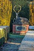 THE LASKETT GARDEN, HEREFORDSHIRE: WINTER, FROST, JANUARY, RECLINING STAG IN THE CHRISTMAS ORCHARD, YEW HEDGES, HEDGING