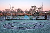 HELMINGHAM HALL GARDENS, SUFFOLK: WINTER, FROST, JANUARY, THE WALLED GARDEN, MAZE AND WOODEN SEAT, BENCH IN THE WALLED KITCHEN GARDEN