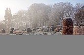 BROUGHTON GRANGE GARDENS, OXFORDSHIRE: WINTER, FROST, JANUARY, BEECH HEDGES, HEDGING, CLIPPED, TOPIARY, FAGUS SYLVATICA, POOL, POND, WATER, STEPPING STONES