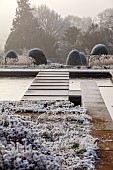 BROUGHTON GRANGE GARDENS, OXFORDSHIRE: WINTER, FROST, JANUARY, POOL, POND, WATER, STEPPING STONES, TERRACE, CLIPPED TOPIARY, YEW