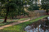 PAINSWICK ROCOCO GARDEN, GLOUCESTERSHIRE: SNOWDROPS, WATER, PATHS, POOL, POND, SWAN POND, TUNNEL ARBOUR, HORNBEAM
