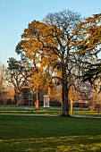 MORTON HALL GARDENS, WORCESTERSHIRE: VIEW OF THE PARKLAND AND MONOPTEROS, SUNSET, MARCH