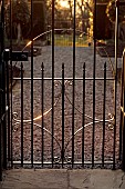 MORTON HALL GARDENS, WORCESTERSHIRE: METAL GATE INTO THE KITCHEN GARDEN, SUNSET