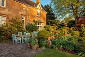 DESIGNER ANGEL COLLINS, SPRING, APRIL: BACK GARDEN, PATIO, TABLE AND CHAIRS, CONTAINERS WITH ORANGE FRITILLARIA IMPERIALIS