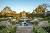 COUGHTON COURT, WARWICKSHIRE: MAY, CIRCULAR POOL, FOUNTAIN, TERRACOTTA CONTAINERS WITH TULIP WORLD FRIENDSHIP, YEW HEDGES, HEDGING, SUNRISE
