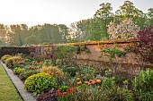 COUGHTON COURT, WARWICKSHIRE: MAY, LAWN, LONG BORDER, WALLED GARDEN, SUNRISE, TULIP BRONZE PERFECTION, EUPHORBIA POLYCHROMA