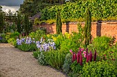 ASHBY MANOR HOUSE, NORTHAMPTONSHIRE: MAY, THE WALLED GARDEN, BORDERS, CLIPPED YEWS, LUPIN MASTERPIECE, IRIS JANE PHILLIPS, PATH