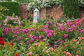 HIGHNAM COURT, GLOUCESTERSHIRE: JUNE, ROSES AND GLASS OBELISKS BY ROBERT BRYANT IN THE WINTER GARDEN TERRACE, WALL