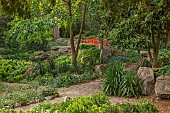 HIGHNAM COURT, GLOUCESTERSHIRE: JUNE, THE FERNERY AND WATER GARDEN, ROCKERY, PULHAMITE ROCKS, FERNS, RED BRIDGE, TRACHYCARPUS FORTUNEI
