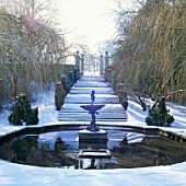 SNOW COVERS THE ORNAMENTAL POOL  STEPS AND WEEPING WILLOWS CORNWELL MANOR  OXFORDSHIRE