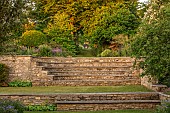 OLD PARK BARN, BUCKINGHAMSHIRE: VIEW ACROSS LAWN TO STONE STEPS AND VIEW TO CIRCULAR SCULPTURE