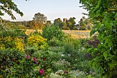 OLD PARK BARN, BUCKINGHAMSHIRE; VIEW THROUGH GARDEN TO THE CHURCH AND WILDFLOWER FIELD