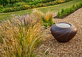 OLD PARK BARN, BUCKINGHAMSHIRE: GRASSES, MELICA CILIATA, SILKY- SPIKE MELIC, NEPETA HILL GROUNDS, GRAVEL GARDEN,  SCULPTURE, CONTAINER BY HANNAH BENNETT