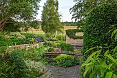 OLD PARK BARN, BUCKINGHAMSHIRE: GRAVEL GARDEN BY BARN, ALCHEMILLA MOLLIS, POND, METAL WATER TROUGH, STONE WALL WITH HOLE