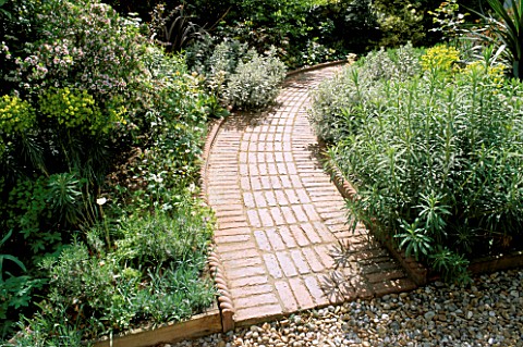 FRONT_GARDEN_DESIGNED_BY_JUDITH_SHARP_WITH_CURVED_BRICK_PATH__EUPHORBIA__DAPHNE_AND_OTHER_SCENTED_PL