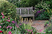 A PLACE TO SIT: COTTAGE STYLE PLANTING SURROUNDS SEAT ON BRICK TERRACE IN THE SPOUT GARDEN  CHELSEA 97. DESIGNER: ROGER PLATTS