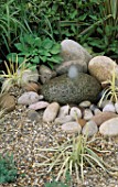 WATER FEATURE: SIMPLE STONE BUBBLE FOUNTAIN SURROUNDED BY GRAVEL. LAMBETH HORTICULTURAL SOCIETY COURTYARD GARDEN. CHELSEA 97