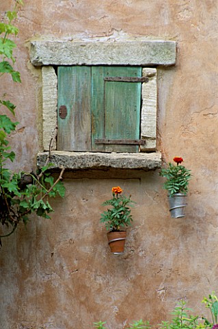 RUSTIC_WINDOW_IN_STONE_WALL_WITH_SIMPLE_WALLMOUNTED_CONTAINERS_BRITISH_SKY_BROADCASTING_GARDEN_DESIG