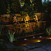 NIGHT-LIT FORMAL POND WITH THREE MONKEY WATER SPOUTS. LIGHTING BY GARDEN & SECURITY LIGHTING. NATURAL & ORIENTAL WATER GARDENS  HAMPTON COURT 97.