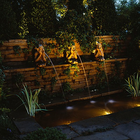 NIGHTLIT_FORMAL_POND_WITH_THREE_MONKEY_WATER_SPOUTS_LIGHTING_BY_GARDEN__SECURITY_LIGHTING_NATURAL__O