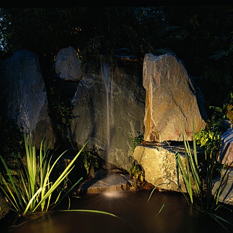 NIGHTLIT_WATER_FEATURE_SIMPLE_FOUNTAIN_OVER_ROCKS_INTO_POOL_LIGHTING_BY_GARDEN__SECURITY_LIGHTING_NA
